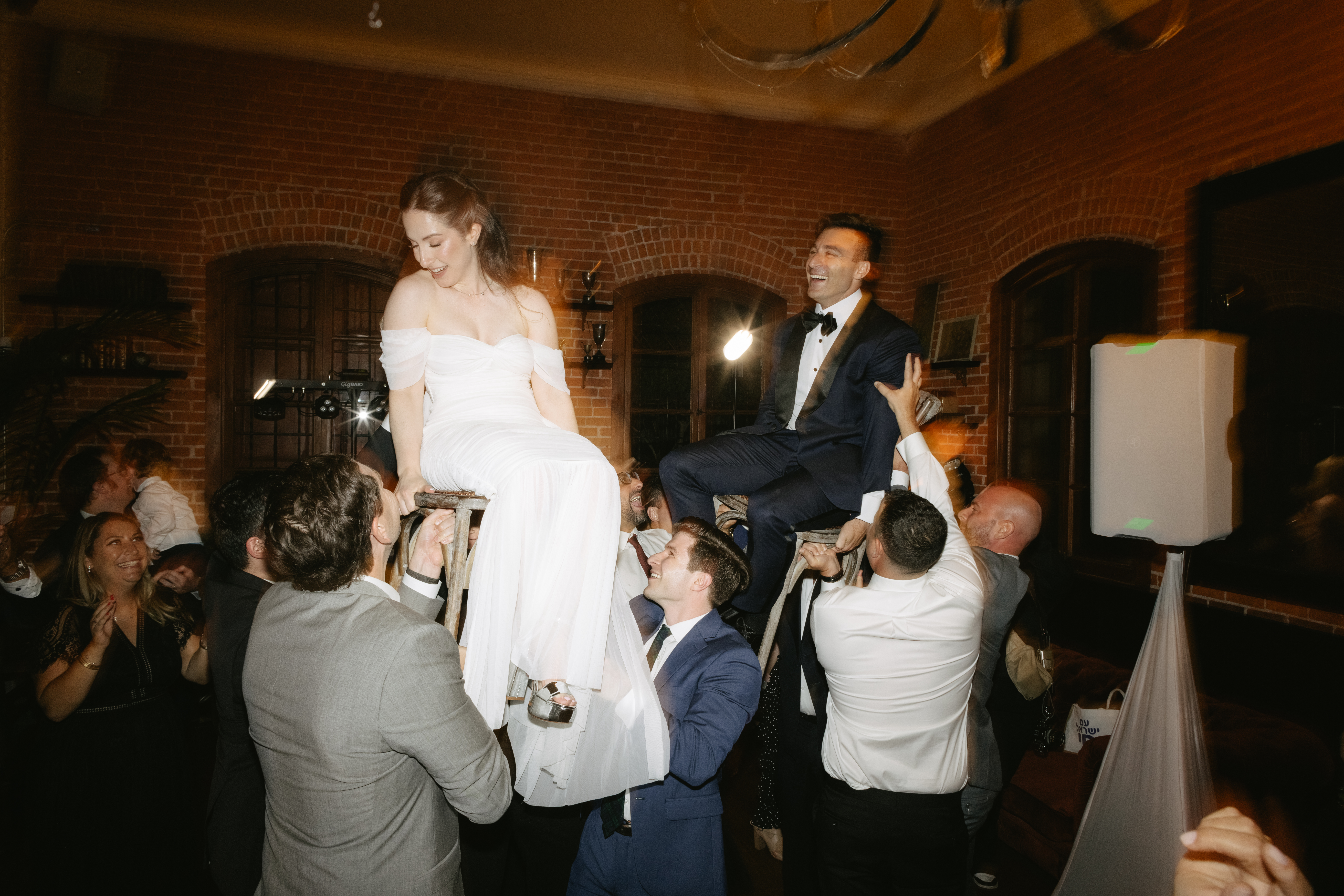 A wedding reception lifting up a couple during a Jewish wedding, captured through documentary style wedding photography