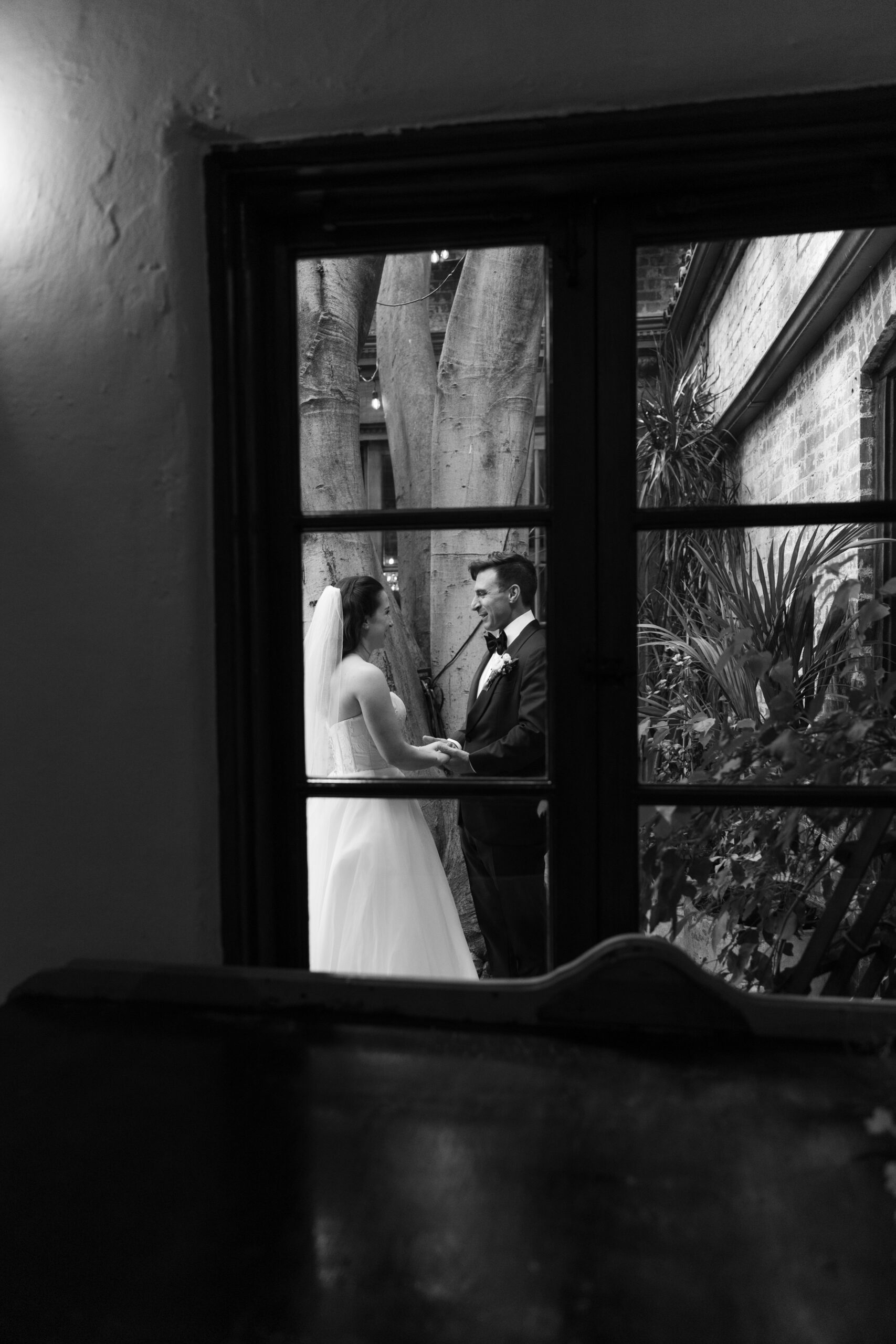 A bride and groom holding hands during a first look, captured through documentary style wedding photography