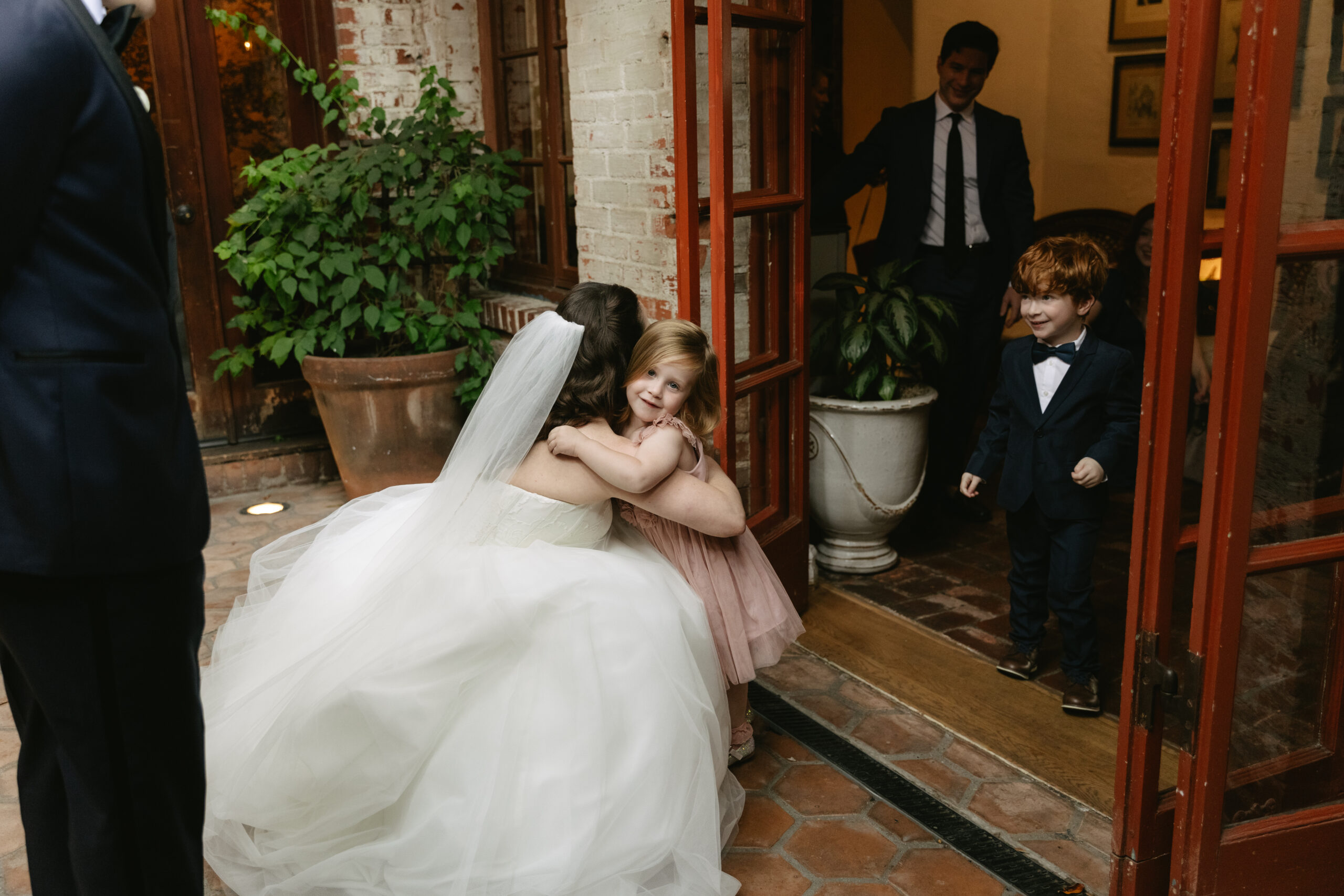 A bride hugging a flower girl at a Carondelet House wedding