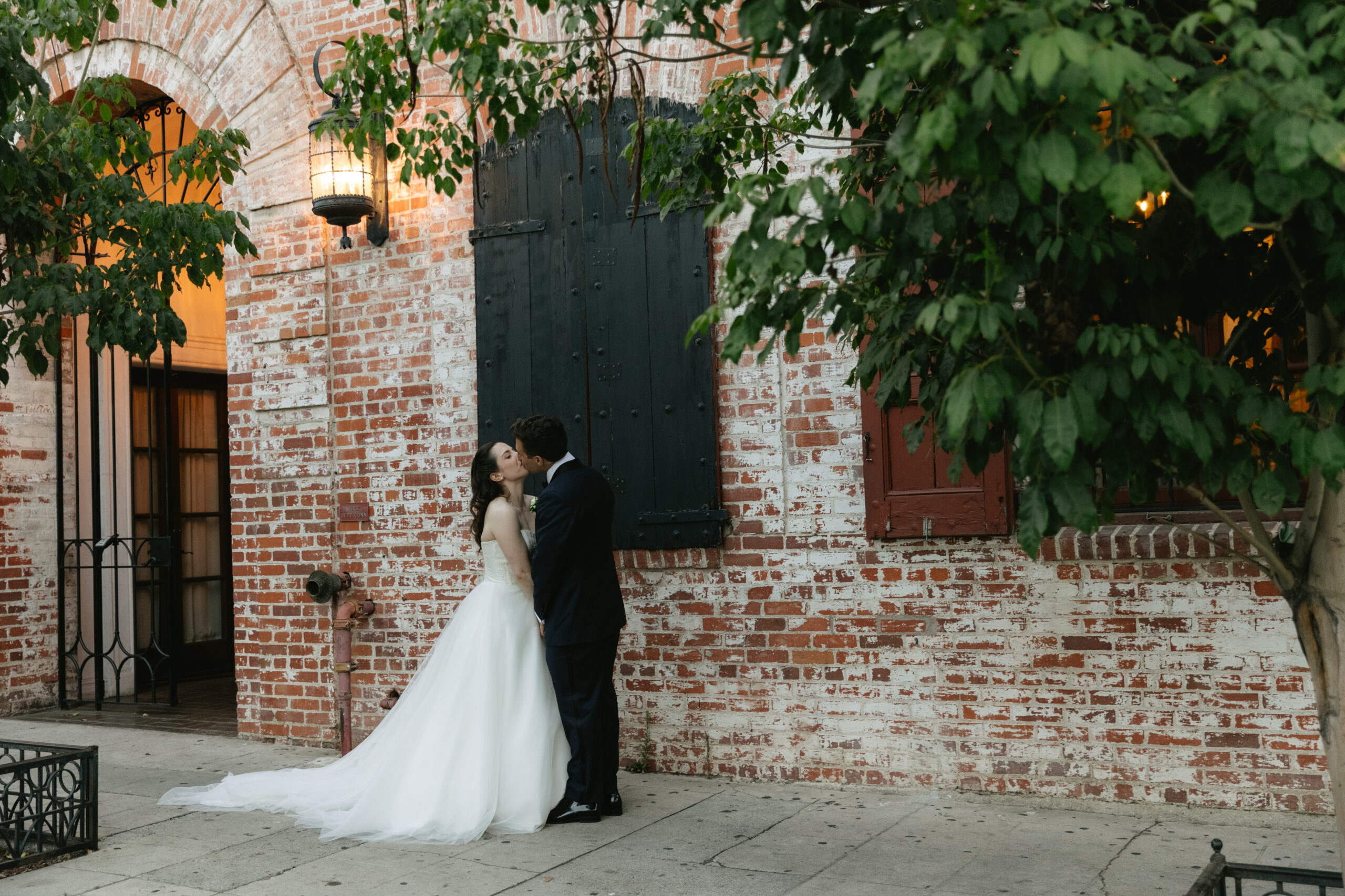A couple kissing outside of their Los Angeles wedding venue, the Carondelet House