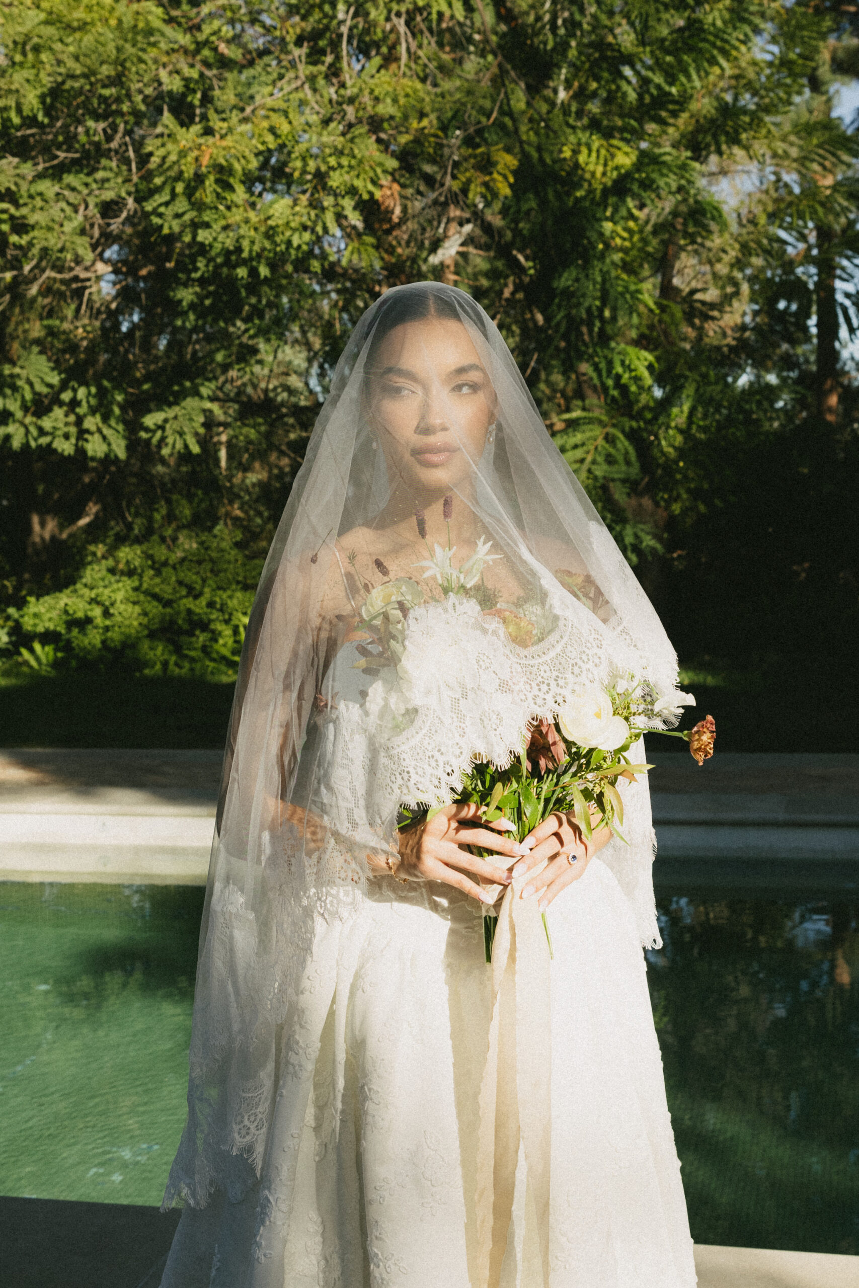 A bride under a blusher veil at etienne estate