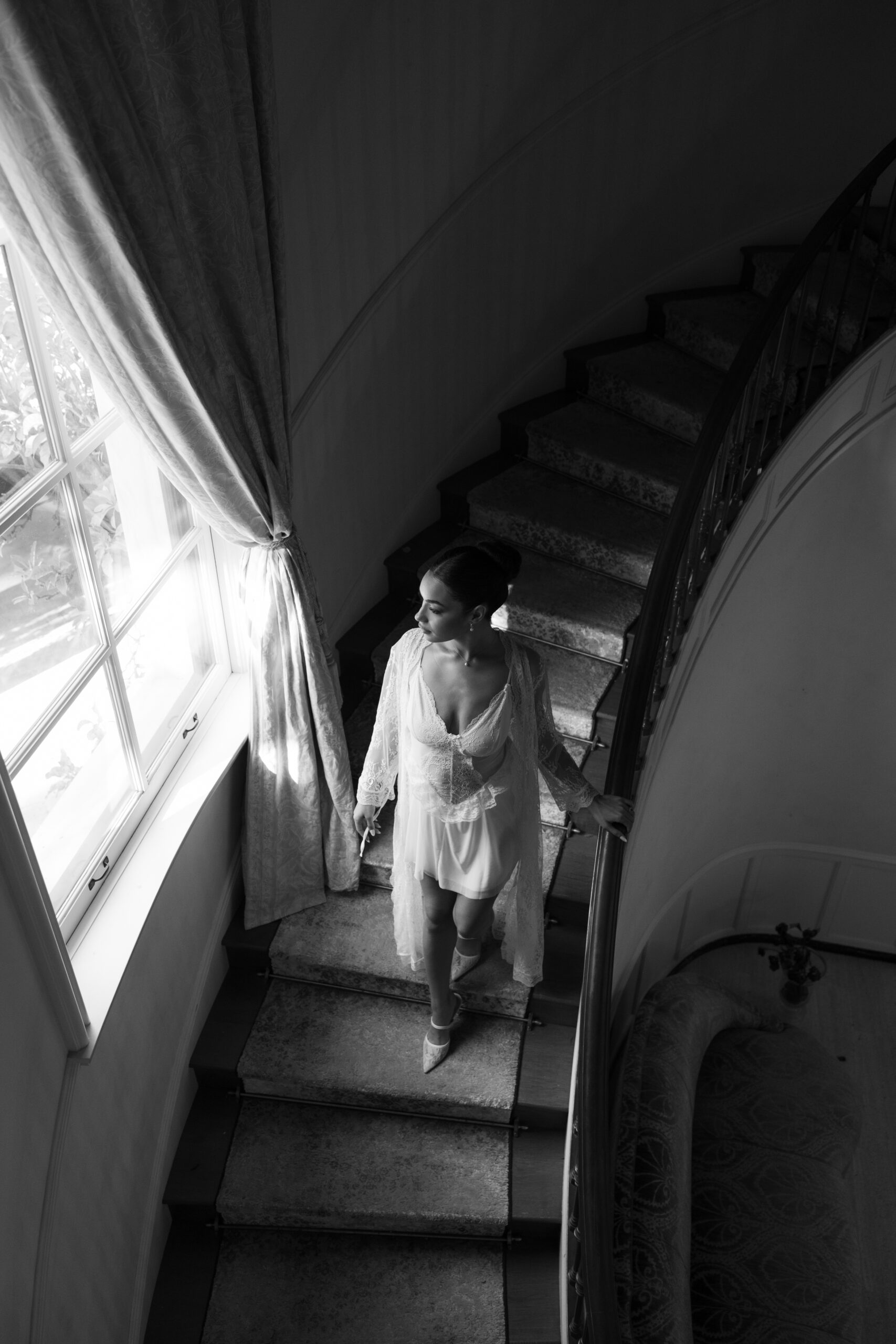 A woman walking down the stairs in a getting ready robe at etienne estate