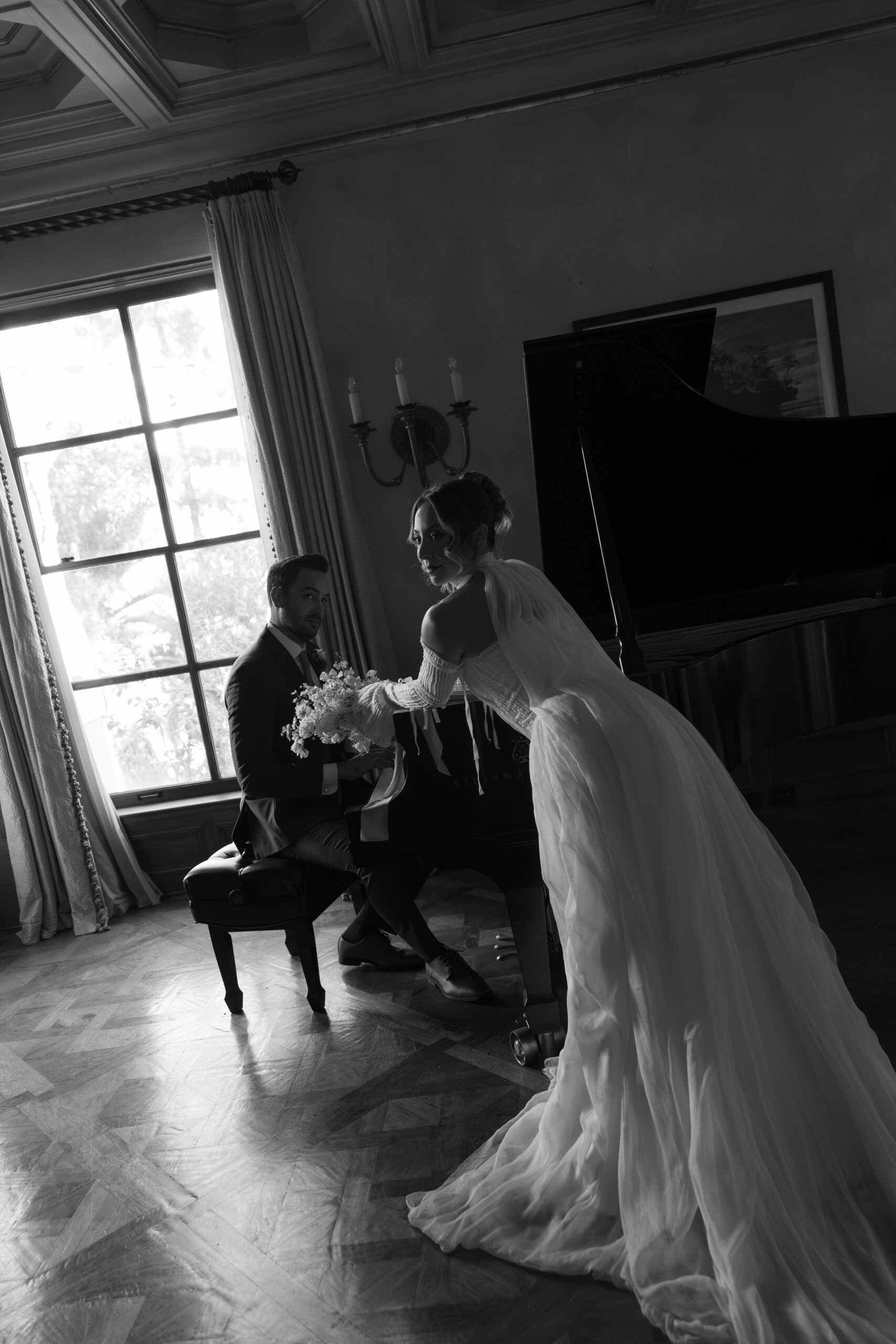 A bride and groom posing with a piano for wedding photos in etienne estate