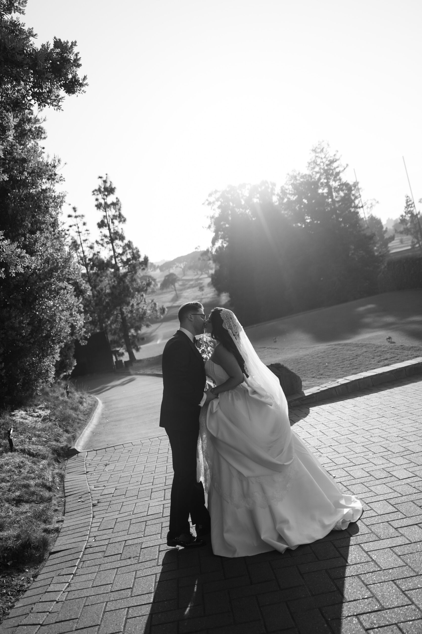 A bride and groom kissing on a golf course wedding venue