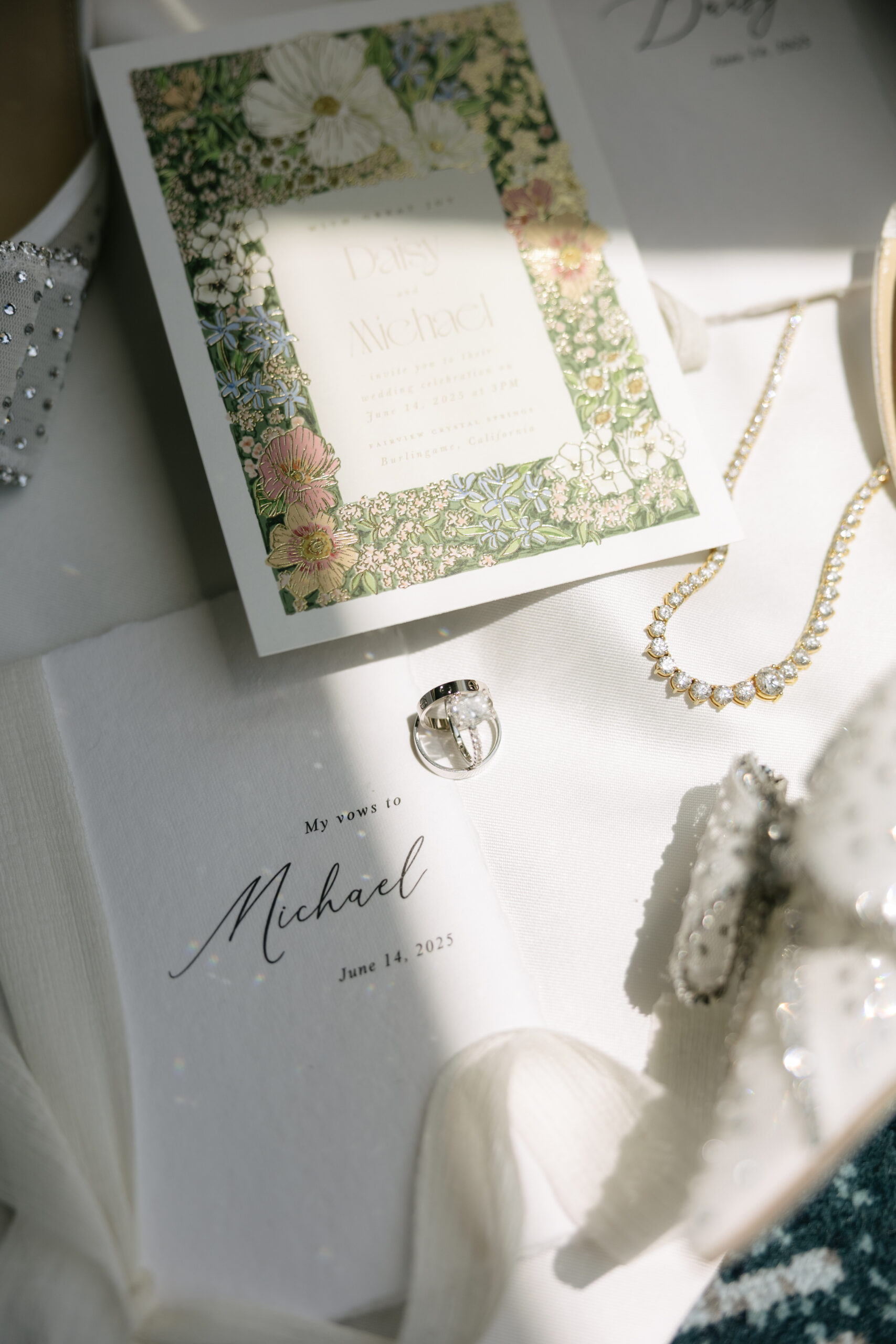 A wedding flat lay with wedding invitations and wedding jewelry
