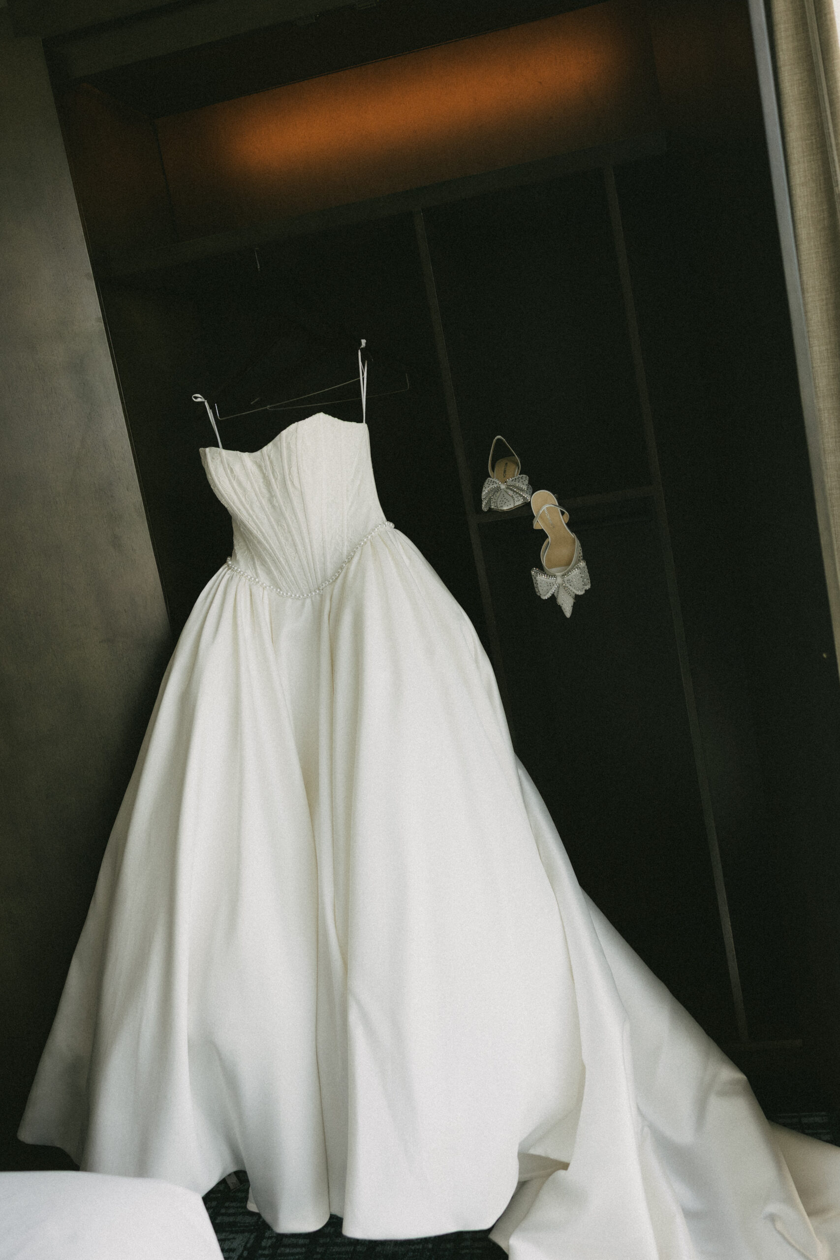 A wedding dress hanging up inside of the getting-ready suites at Peninsula golf and country club
