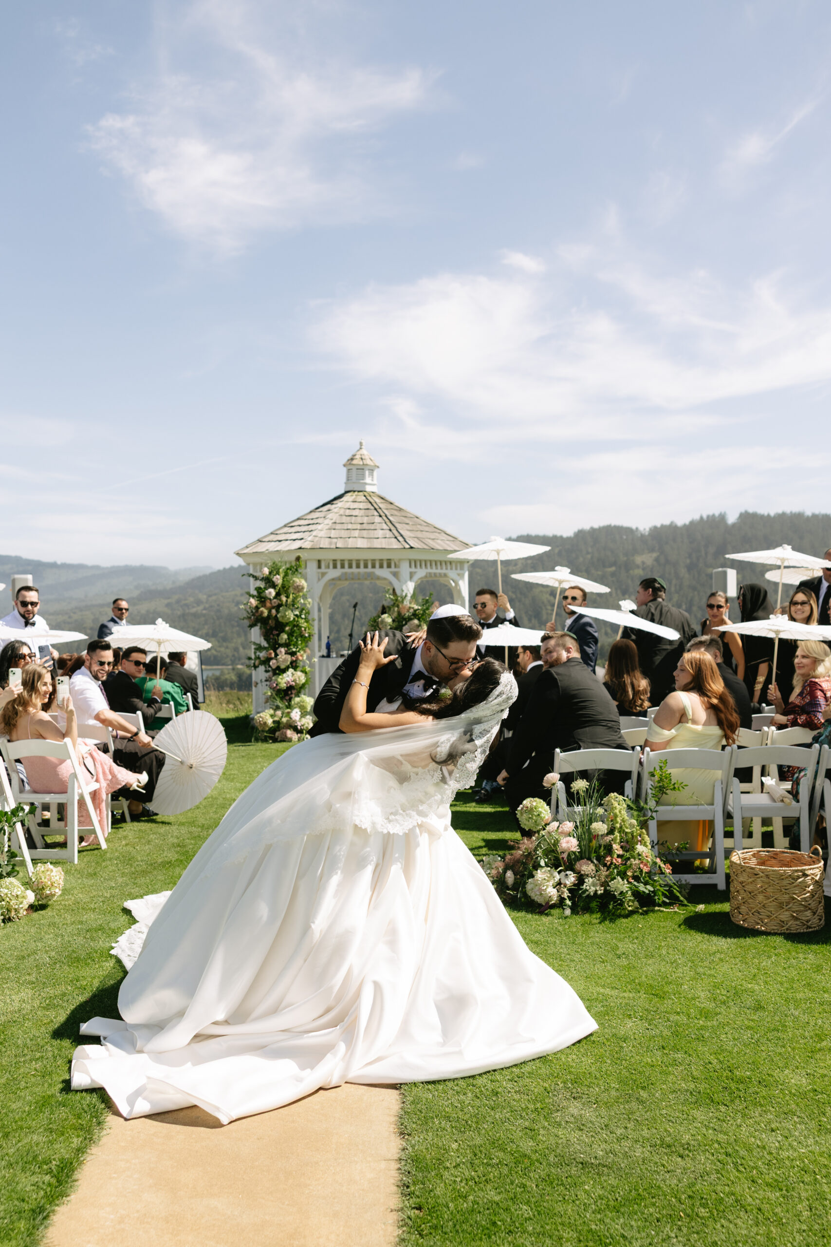 A bride and groom kissing after their wedding ceremony at Peninsula Golf and Country Club